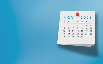 2023 November Calendar on Note Pad Against Blue Background